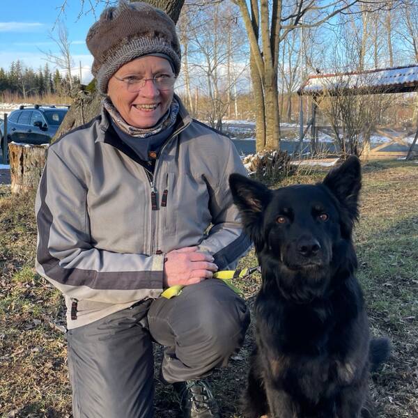 Ingrid Heller och hennes svarta hund.