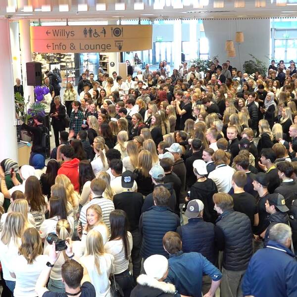 En stor folksamling bestående av ungdomar som besöker UF-mässan i Umeå tittar på när två ungdomar på scen berättar om sin företagsidé.