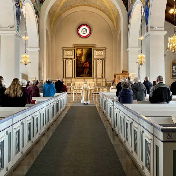 En bild längst bak inifrån Svenska kyrkan i Vetlanda under en gudstjänst.