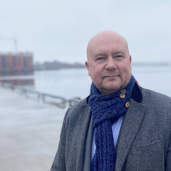 Man på kajen i innerhamnen i Karlshamn med byggnad, horisonten och fartyg bakom sig. Mannen heter Magnus Gärdebring och är moderat kommunalråd i Karlshamn.