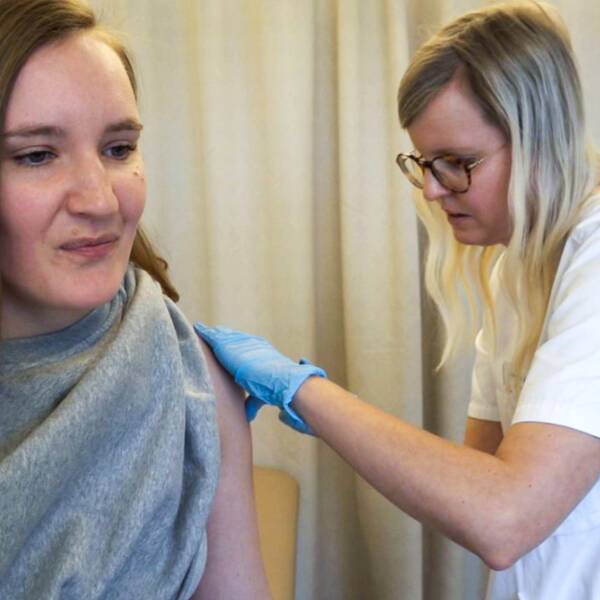 Kvinna får spruta av barnmorska. HPV-vaccin.