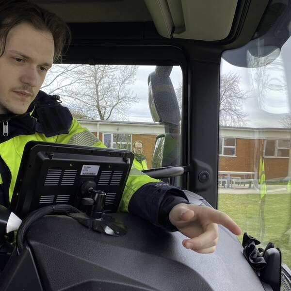 Vadym Bilotskyi sitter i en av NSR:s sopbilar och pekar på den nya AI-kameran som ska upptäcka bland annat hål i vägunderlaget.