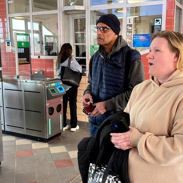 Resenärer på Kungsängens pendeltågsstation tittar på avgångstavlan
