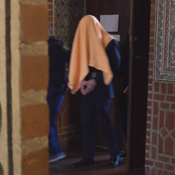 En bild på 22-åringen gåendes ut rättssalen med en gul handduk över huvudet