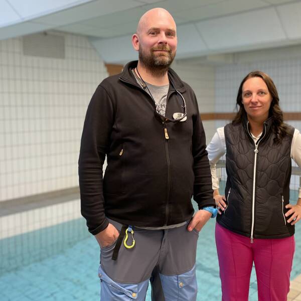 Kommunalrådet Angelica Karlsson (C) och idrottsläraren Patrik Roth berättar om eleverna på Kvarndammskolan som simtränar i en liten bassäng.