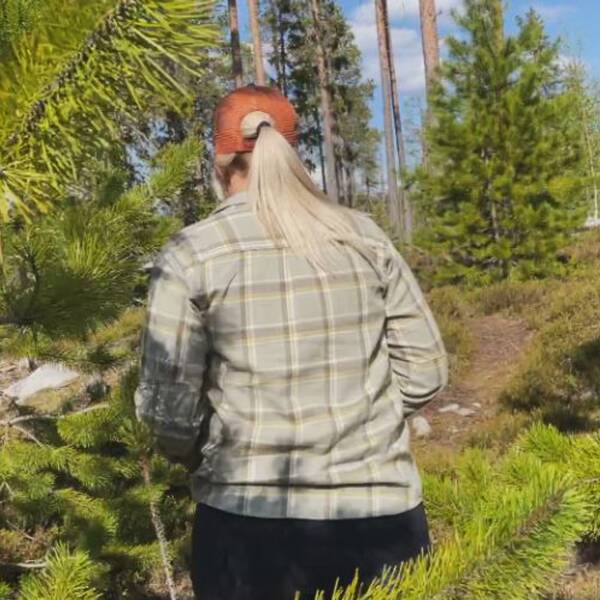 En bild på en kvinnas rygg när hon går i skogen.