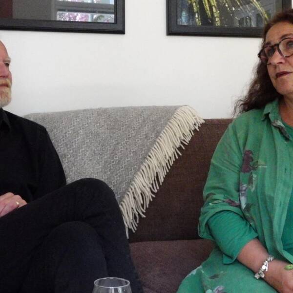 Man i svart skjorta och kvinna i grön blus sitter bredvid varandra i soffa. Familjehem, Karlskrona, Annika och Lasse Fagerberg.