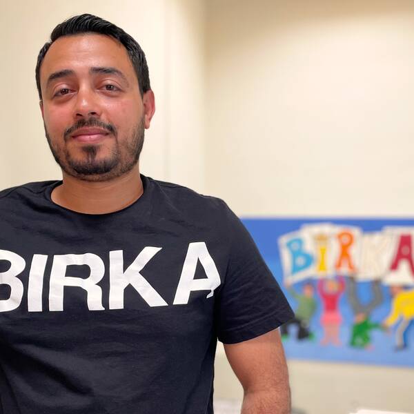 Man med mörkt hår och lite skägg tittar rakt in i kameran. Har en t-shirt med stora bokstäver där det står Birka.
