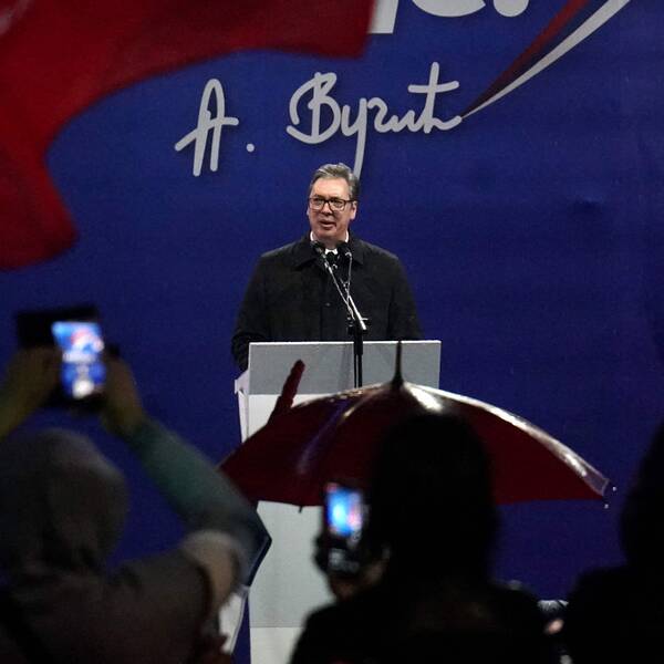 Serbiens hårt kritiserade president Aleksandar Vucic vid ett tal under en manifestation i regnet i Belgrad på fredagen.
