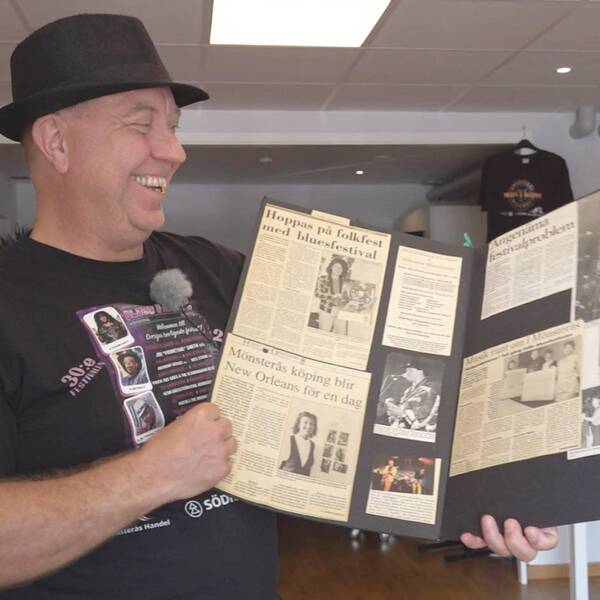 Artistansvarige Jan Aldorssons visar upp en bok med tidningsklipp från bluesfestivalens historia.