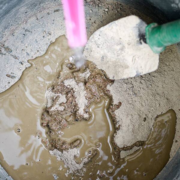 Cement i hink med spade.
