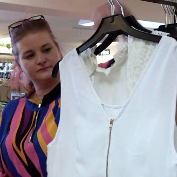Åsa Ekered visar upp en vit studentklänning i Myrornas butik i Jönköping