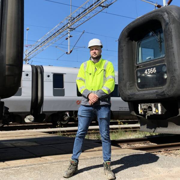 André Bjerborn från Trafikverket står mellan två tåg som står stilla och med ett tredje tåg bakom sig i Helsingborg där en ny station ska stå klar till slutet av 2023.