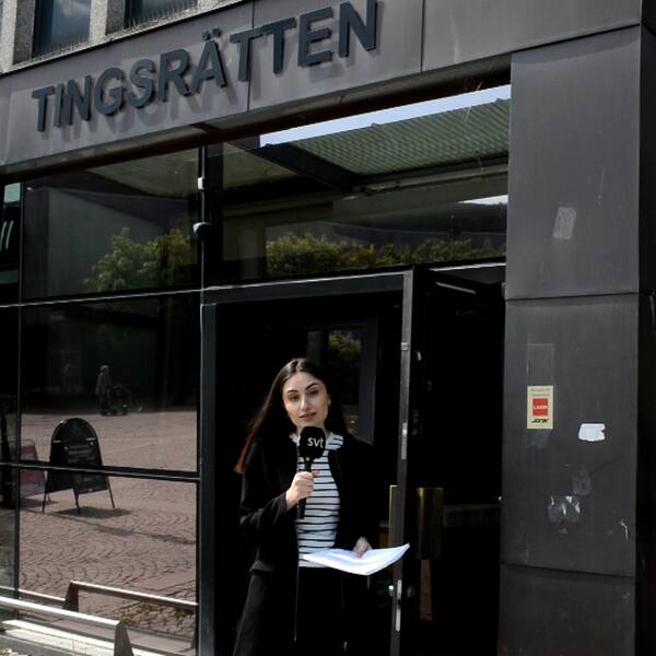 Reportern Nada Razooq – en ung kvinna med mikrofon – står framför entrén till tingsrätten i Södertälje