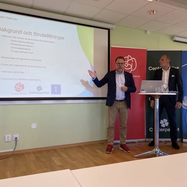 Tre regionspolitiker står framför en projektorduk.
