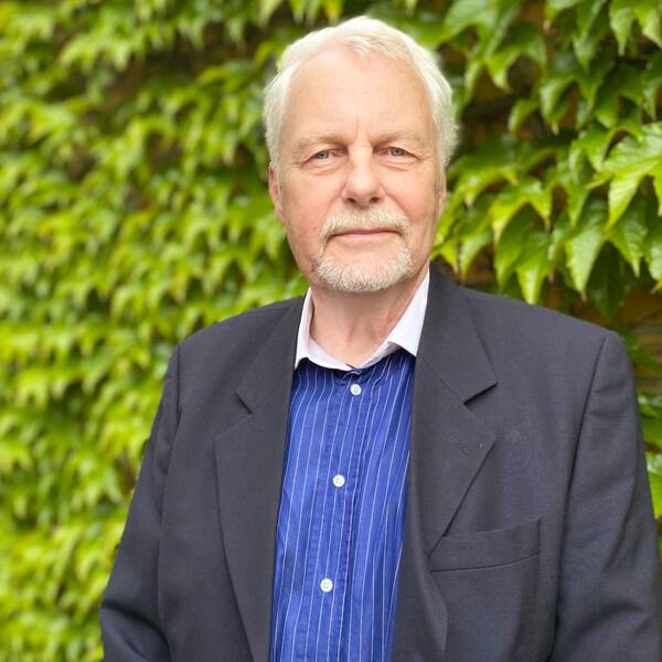 Politikern Roland Norrman iklädd en blå skjorta och svart kavaj.