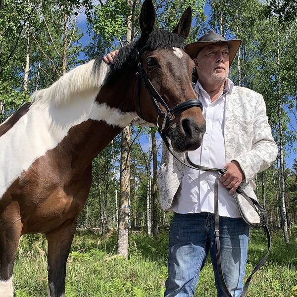 Staffan Gising med sin svartvita häst i skogen.