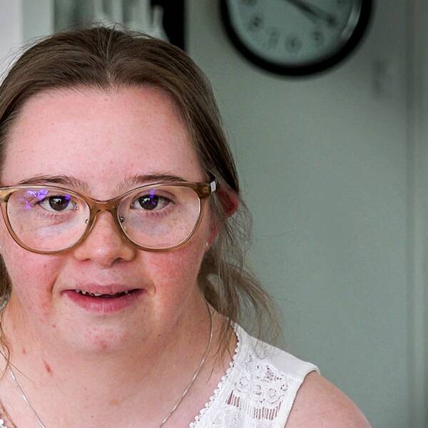En bild på Hedvig Roos Rahmquist. Hon tittar in i kameran och ser glad ut.
