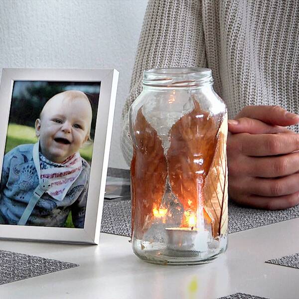 Matteos mamma sitter vid köksbordet vid en ljuslykta och en bild på sin son.