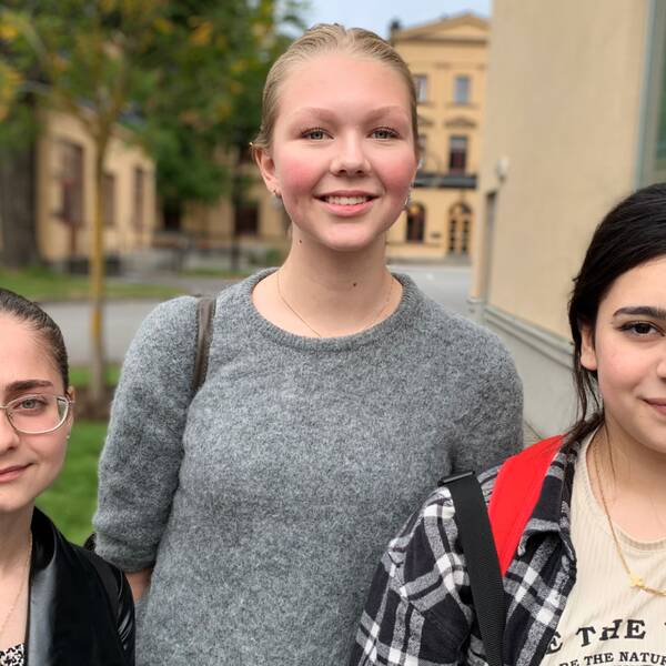 Tre unga tjejer: Shahed Shakweh, Carolina Horn-Berlin och Rand Naia, fotograferade utomhus framför gula byggnader.