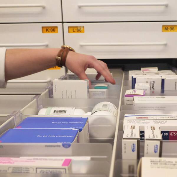 läkemedel och mediciner i en låda på apoteket, hand som lyfter upp en burk