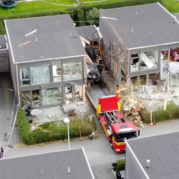 Drönarbild på två radhus som har utsatts för explosion. Polis och bärgningsbil på plats.
