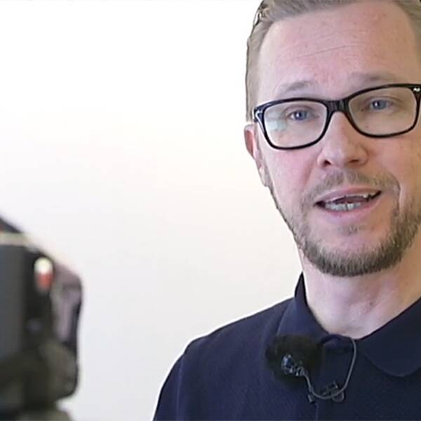 Micke Sandström framför en videokamera.