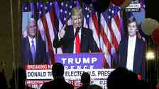 Guests watch a television broadcast of President-elect Donald Trump as he gives his acceptance speech, during an election night event organized by the U.S. Embassy in Skopje, Macedonia, Wednesday, Nov. 9, 2016. Trump defeated Hillary Clinton to be elected the 45th president of the United States. (AP Photo/Boris Grdanoski)