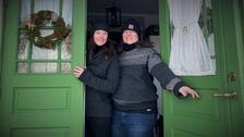 Bild på Jenny och Jenny som har på sig tjocka tröjor och mössa när de står i dörröppningen till sitt hus i Åbyggeby, där de lyckats minska elförbrukningen rejält.