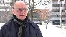Polischef Erik Nord. En man i rock, halsduk och glasögon, kalt huvud, stående framför polishuset i Göteborg.