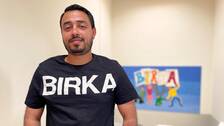 Man med mörkt hår och lite skägg tittar rakt in i kameran. Har en t-shirt med stora bokstäver där det står Birka.