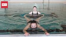 En bild på två tjejer, Victoria Lundqvist och Alice Tengelin, i en pool. Den ena av dem flyter på mage i vattnet och håller i poolkanten och den andra håller i hennes ben.