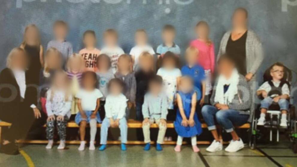 Elis sitter i sin rullstol till höger i bild. Resten av klassen sitter till vänster i en grupp.