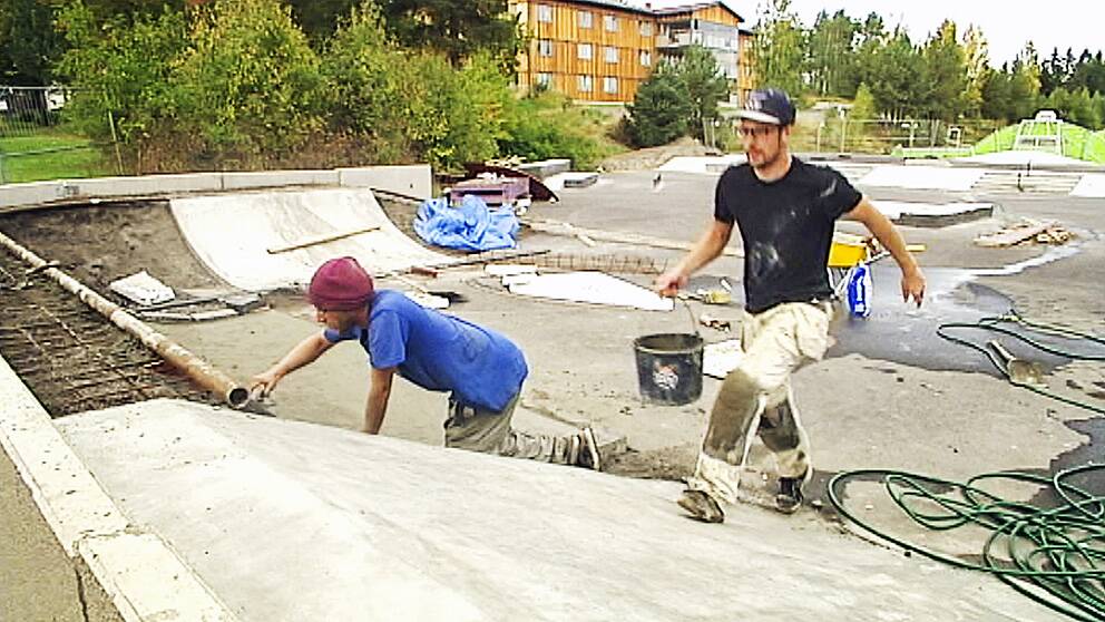Conny Björklund putsar för att få till rätt kurvning på en ramp medan Joakim Lovén kommer med en ny hink med betong.