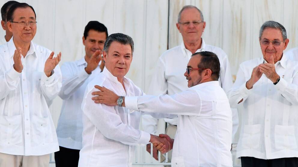 Colombias president Juan Manuel Santos och Farcledaren Rodrigo Londono förenas i ett historiskt handslag efter att ha skrivit på fredsavtalet.
