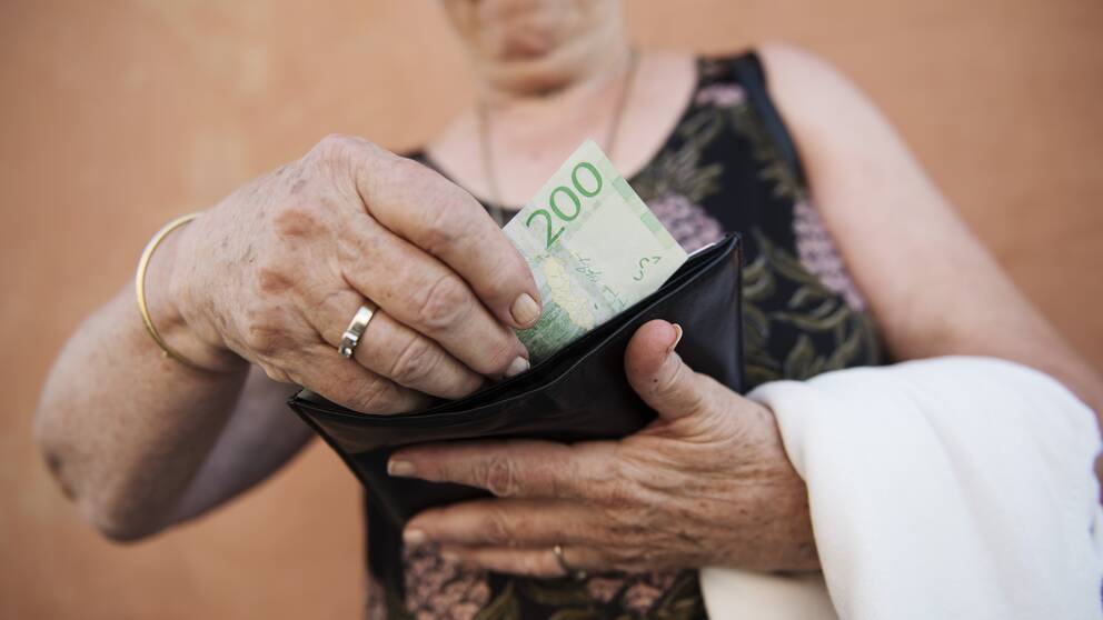 kvinna håller i plånbok