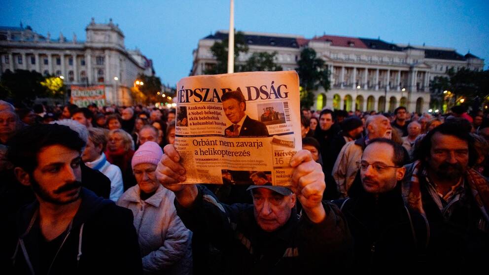 En demonstrant håller upp det sista tryckta exemplaret av den nu nedlagda oppositionella tidningen Népszabadság.