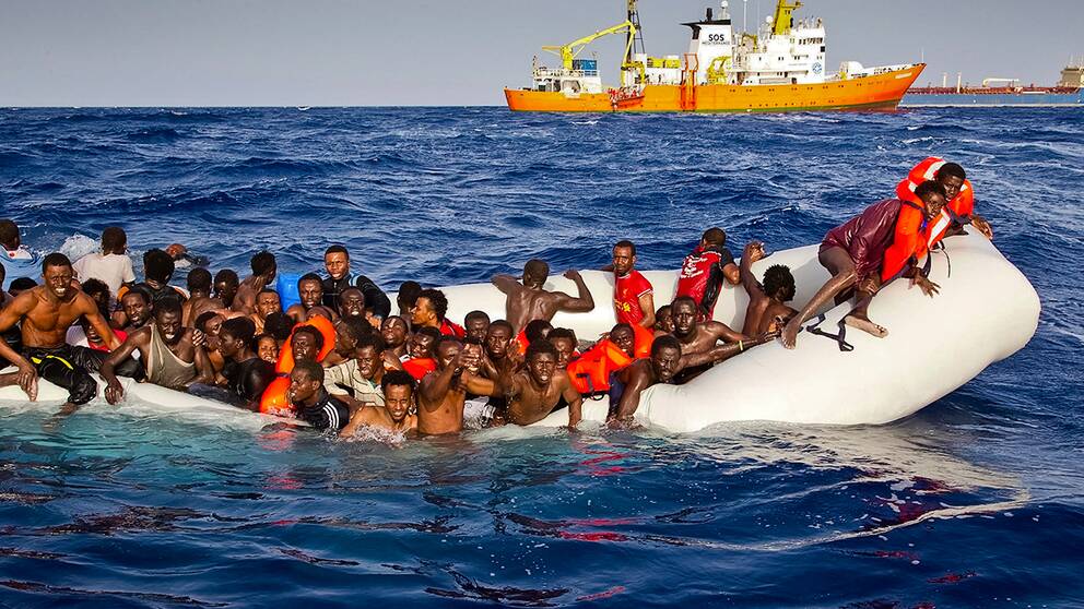 Migranter på en kapsejsad båt utanför den italienska ön Lampedusa. 