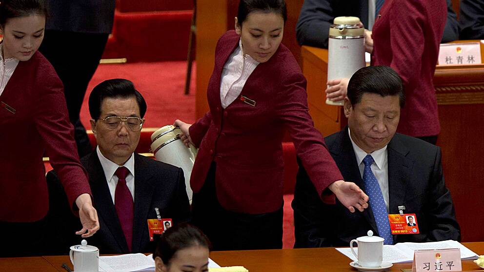 Kinas avgående president Hu Jintao och hans förväntade efterträdare Xi Jinping får påfyllning av te av två värdinnor vid folkkongressens öppnande.