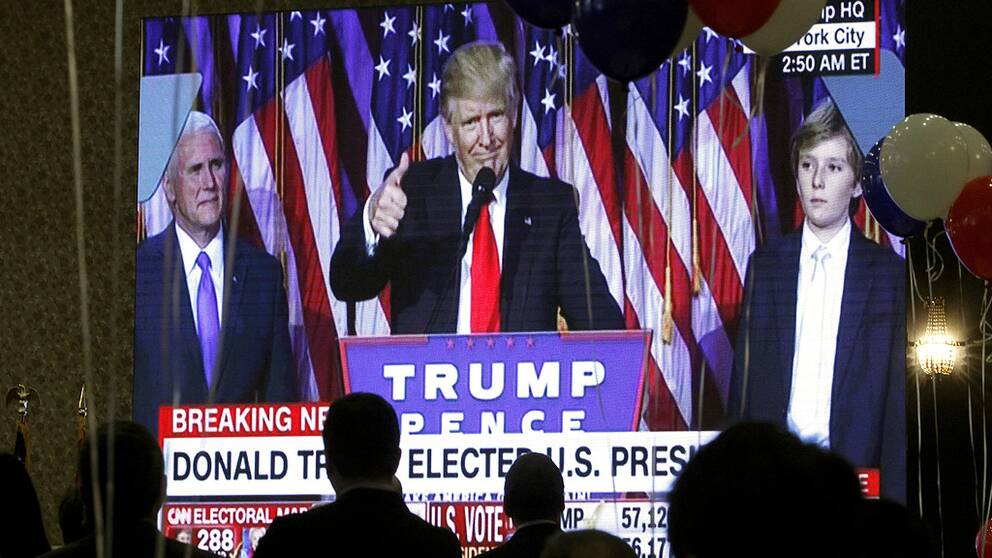 Guests watch a television broadcast of President-elect Donald Trump as he gives his acceptance speech, during an election night event organized by the U.S. Embassy in Skopje, Macedonia, Wednesday, Nov. 9, 2016. Trump defeated Hillary Clinton to be elected the 45th president of the United States. (AP Photo/Boris Grdanoski)