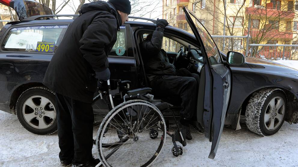 Färdtjänsttaxi i Stockholm. En man med rullstol ska kliva in i en bil.