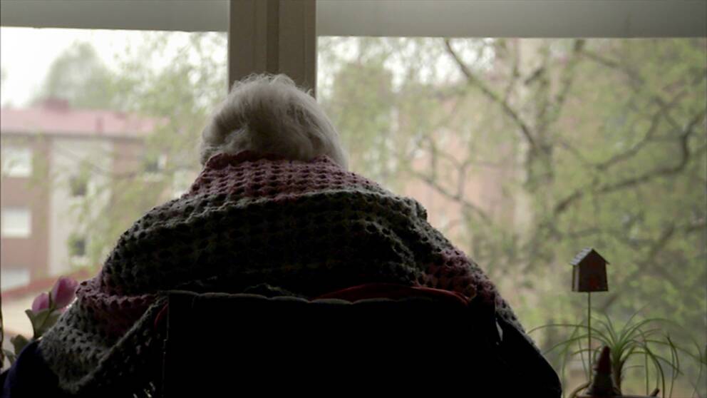 äldre kvinna framför ett fönster