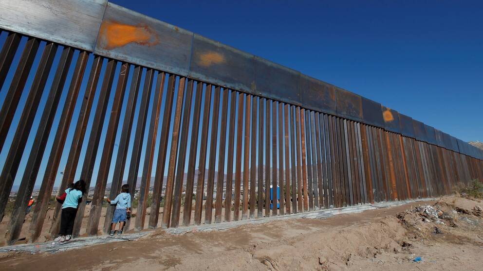 Barn leker vid en nybyggd del av muren mellan Mexiko och USA vid Sunland Park. 