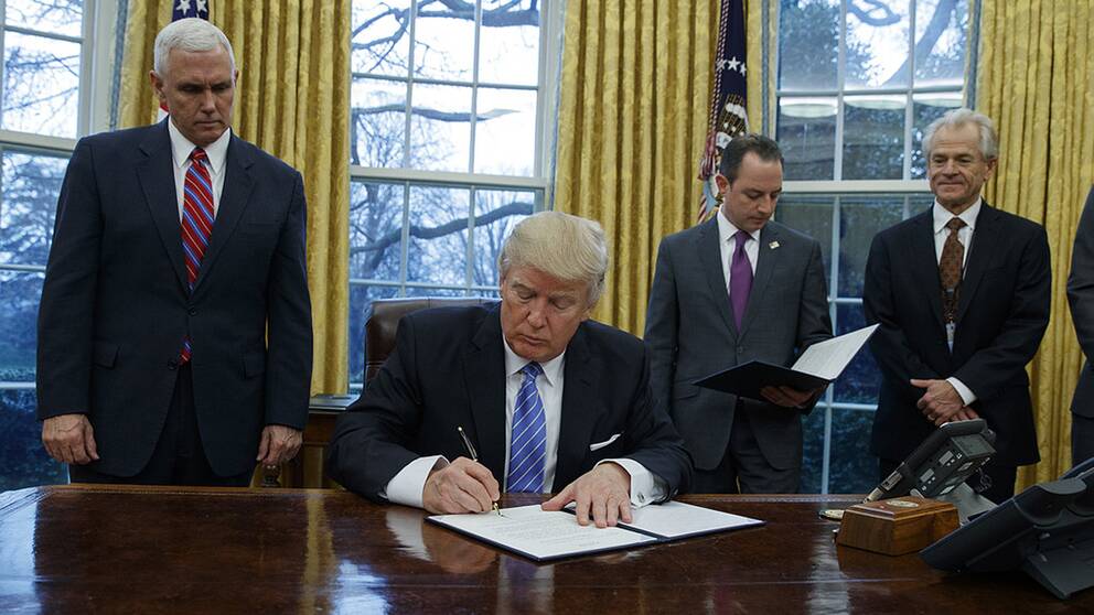 DOnald Trump skriver under ett pappet.
