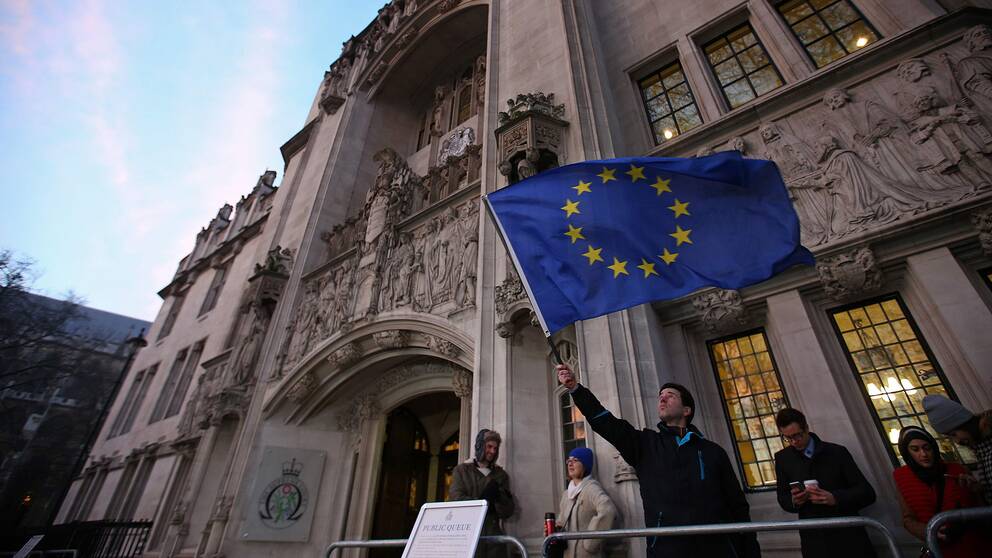 En man viftar med EU-flaggan utanför Storbritanniens högsta domstol i London.