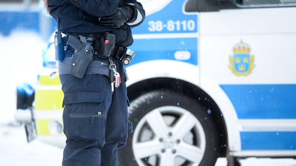 Polis vid en polisbil.