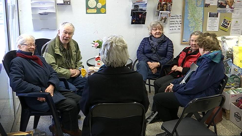 Sex pensionärer sitter samlade runt ett fikabord.