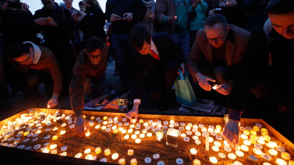 Människor hedrar offren i attacken, tänder ljus
