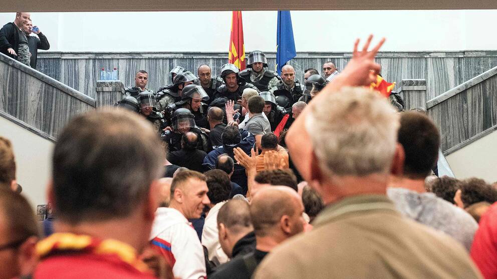 Polismän försöker stoppa protesterande nationalister från att ta sig in i parlamentet i Skopje.