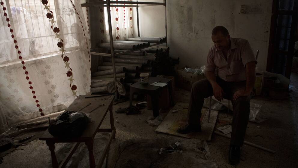 Aisam Hany sitter i vad som en gång var hans fina vardagsrum, nu tittar han ner på en halvfärdig bomb. Islamiska staten använde hans hem som vapenfabrik.